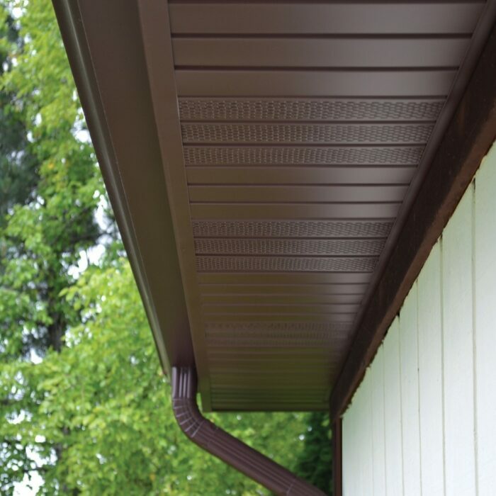 A close-up image shows brown gutters and soffit installed on a white house.