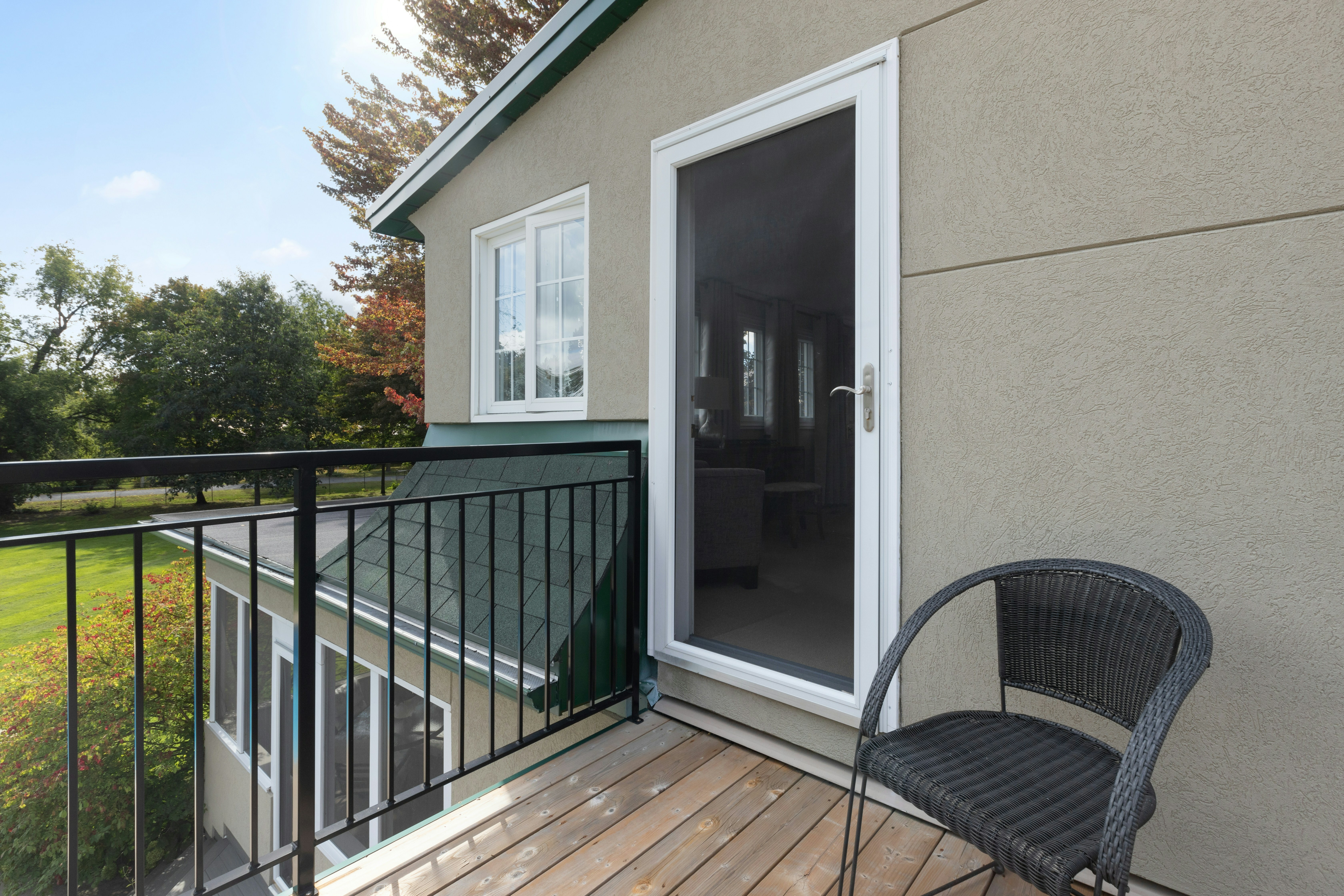 A tan home has a green gutter system and white trim.